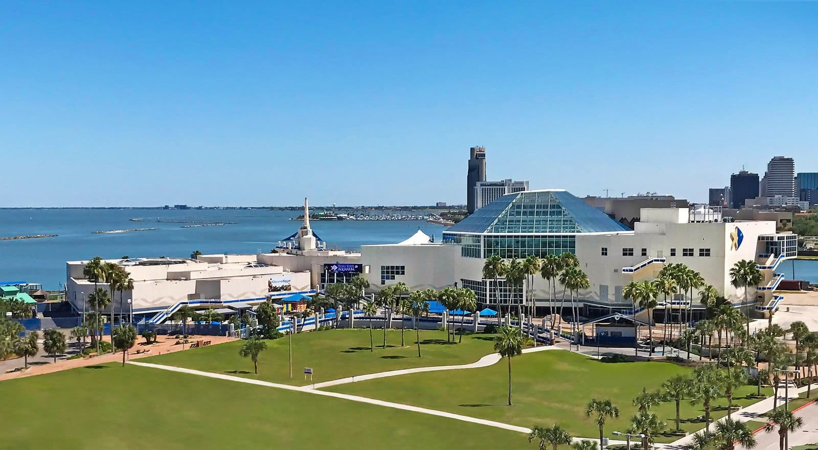 The Texas State Aquarium on the bayfront with the Corpus Christi skyline behind it